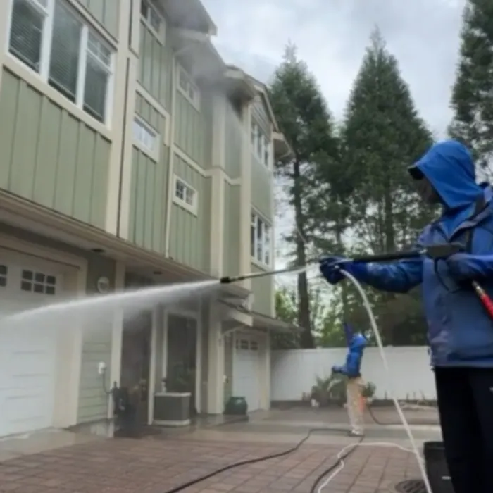 Crew washing the side of a three-storey townhouse building with garage doors below, Vancouver BC